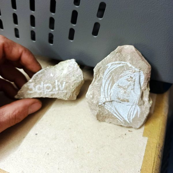 Two engraved stones — logo and drawing