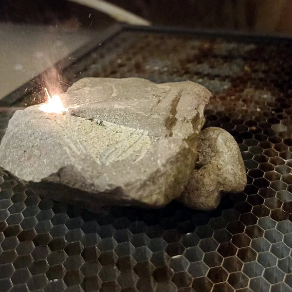 Our laser engraving a stone in our workshop